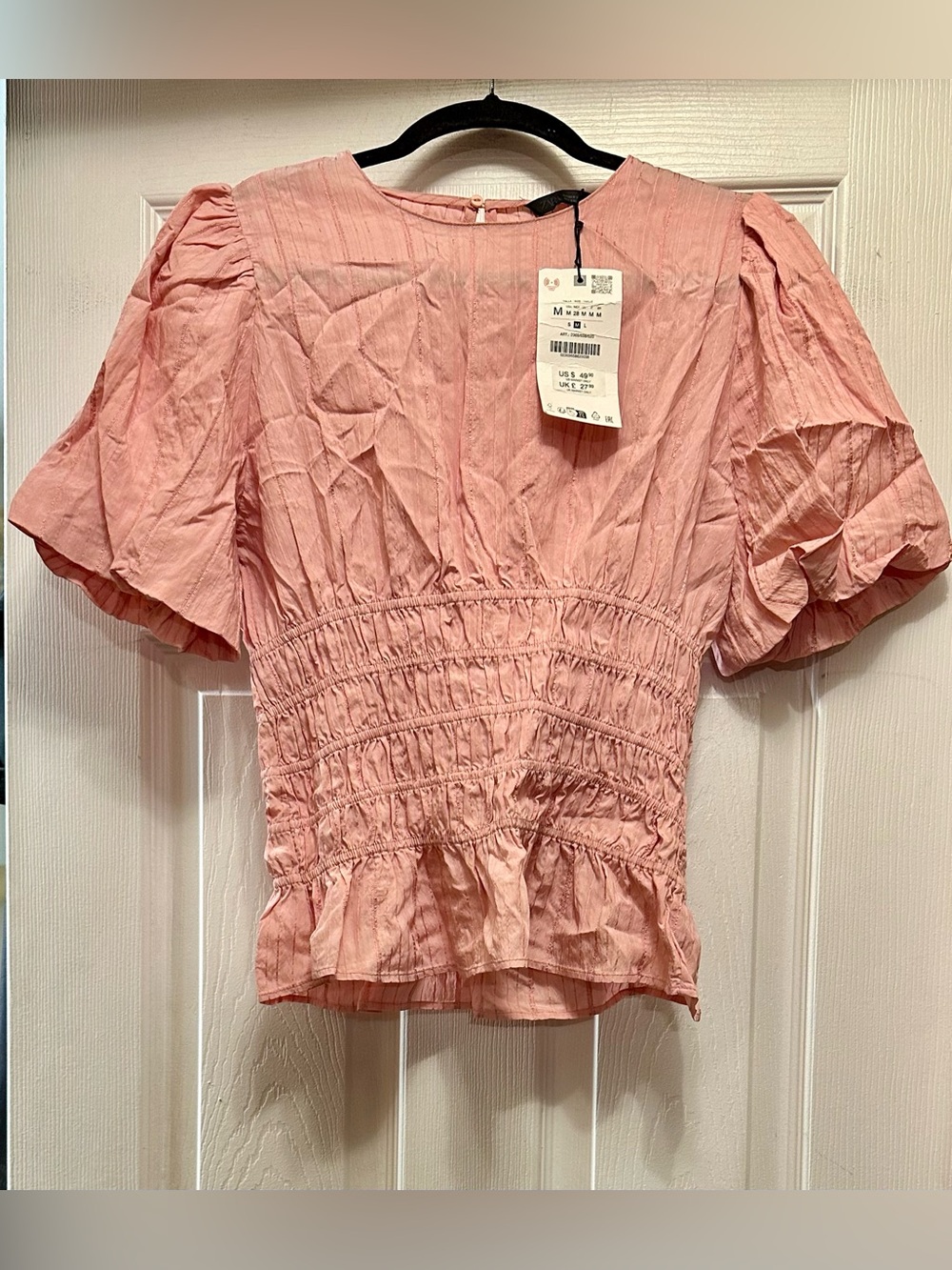 pink Zara smocked puff-sleeve top featuring a textured finish and a ruffled pepl